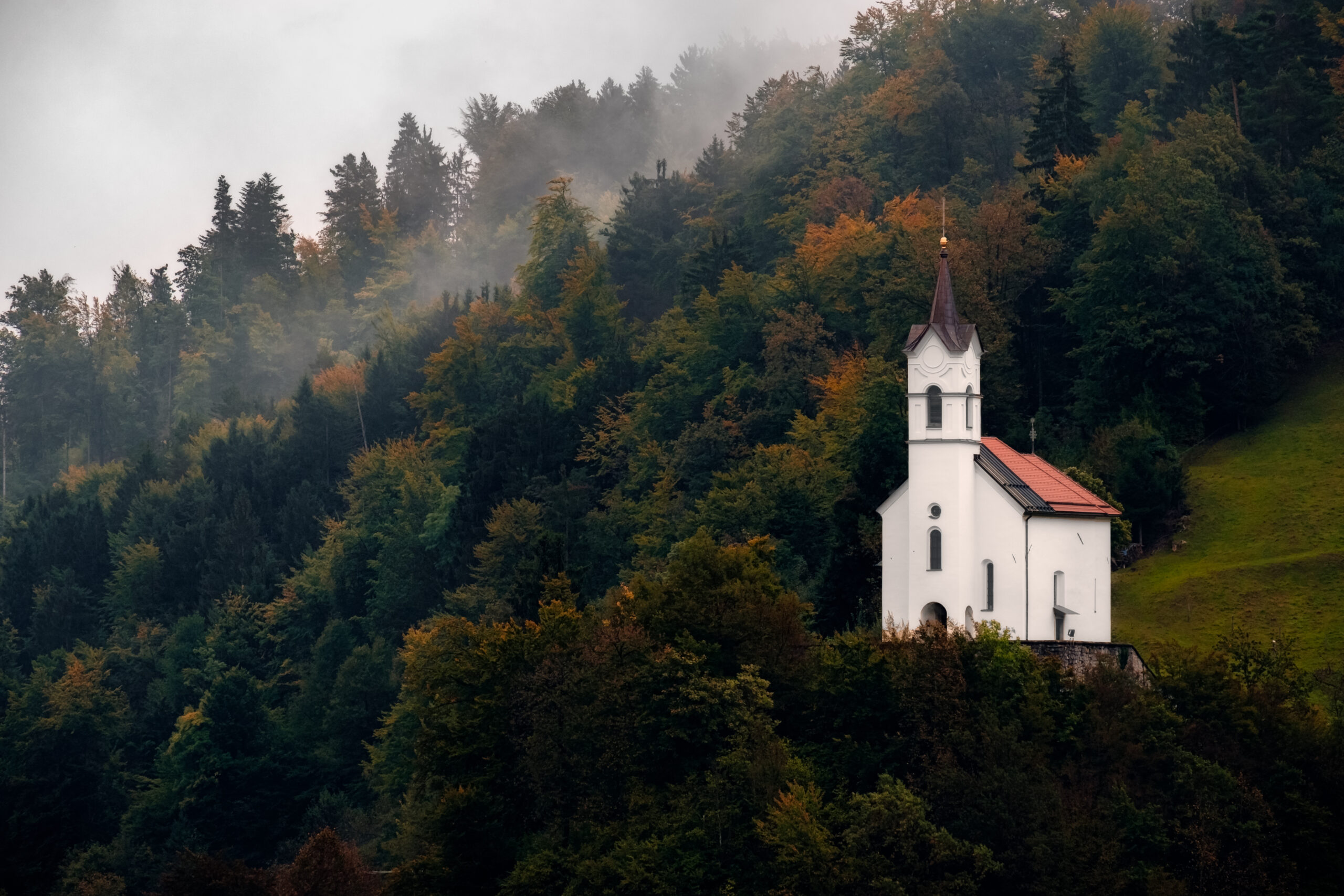 Scenic view of small church on a hill among trees
