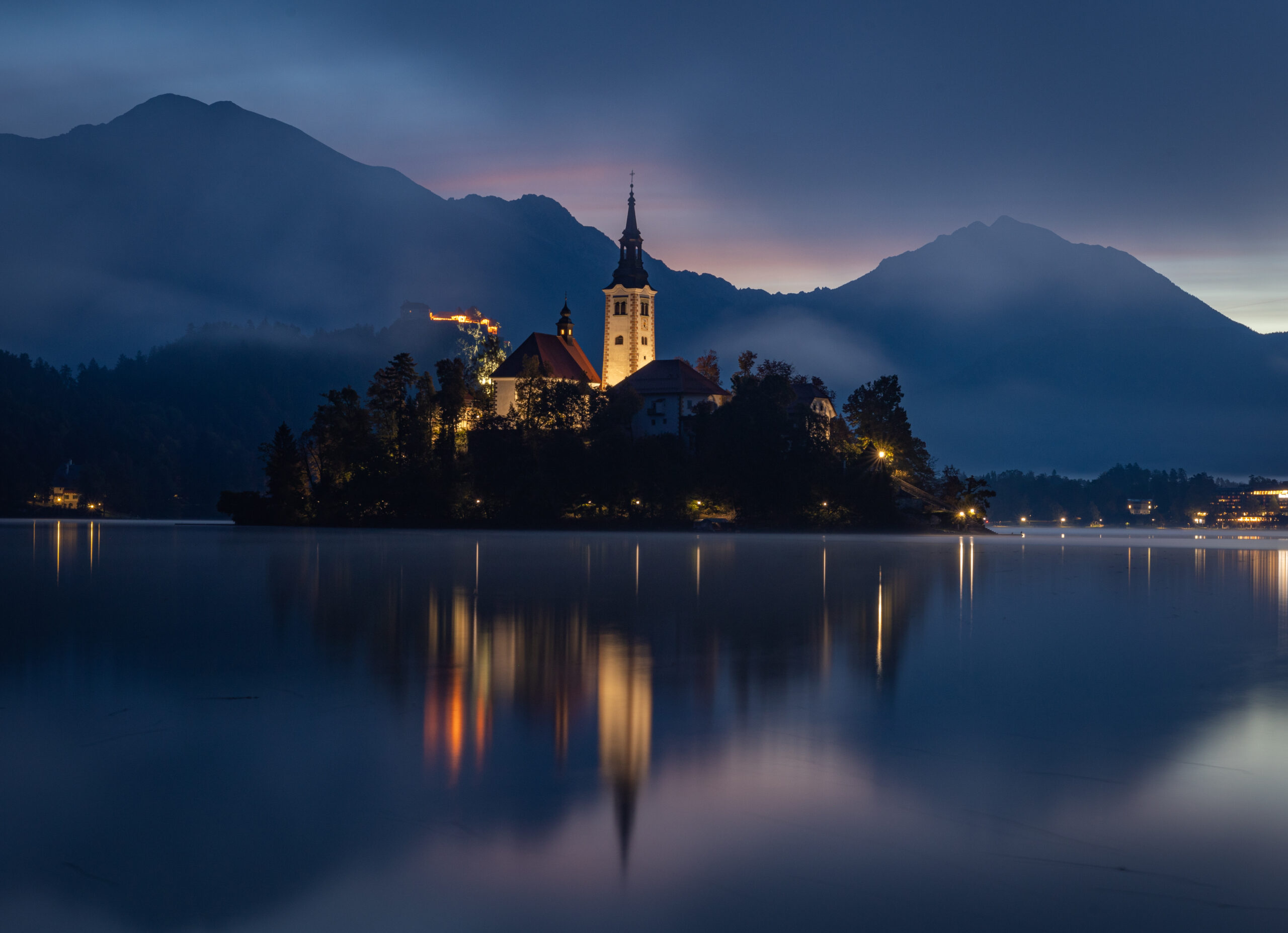 Town on a lake with alps in background. Lovely evening mirror reflection in lake.